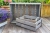 szare-skrzynki-drewniane-ustawione-razem-na-tarasie-obok-doniczek
